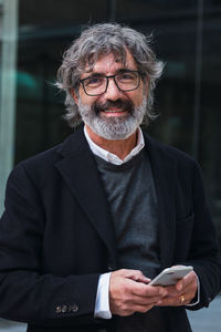 Portrait of young man standing against wall