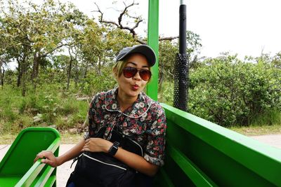 Portrait of woman wearing sunglasses sitting in land vehicle