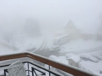 Snow covered railing by building during winter