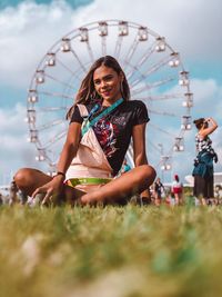 Young woman with ferris wheel in amusement park