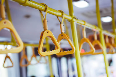 Close-up of yellow metal hanging on rack