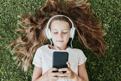 Portrait of girl using mobile phone in grass