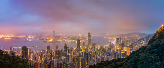 Illuminated cityscape against sky at night