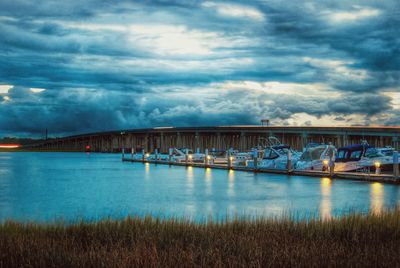 Bridge over river against cloudy sky