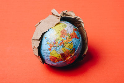 Close-up of globe over red background