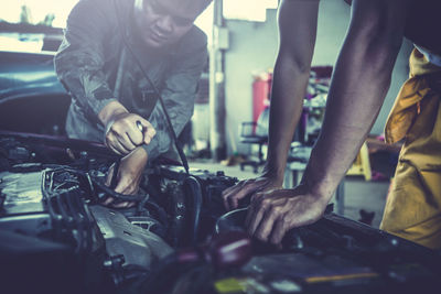 Male mechanics repairing car in workshop