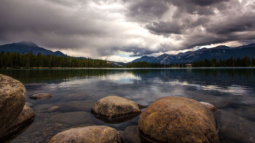 Scenic view of lake and mountains against cloudy sky