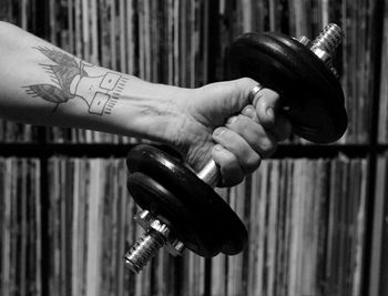 Cropped tattooed hand of man holding dumbbell