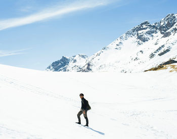 Man standing on snow covered mountain against sky
