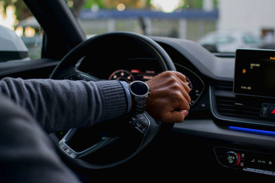 Cropped hands of man driving car