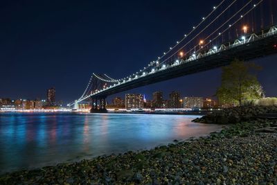 Suspension bridge over river at night