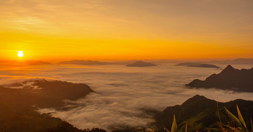 Scenic view of silhouette mountains against orange sky