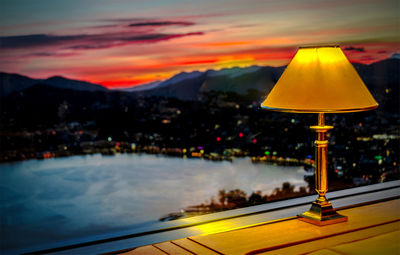 Illuminated city against sky during sunset