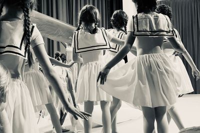 Rear view of women standing on clothesline