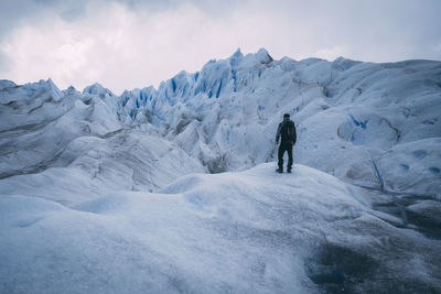 Full length of hiker standing on glacier