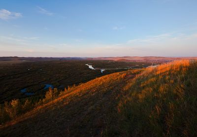 Scenic view of land against sky during sunset