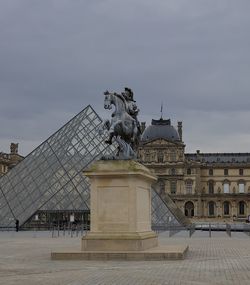 Statue of historical building against cloudy sky