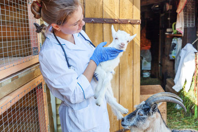 Side view of woman with goat