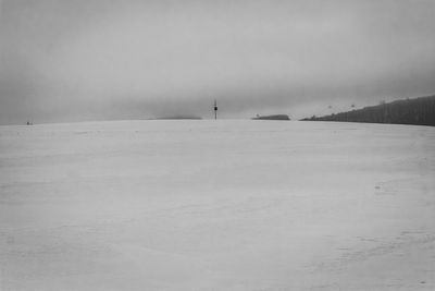 Scenic view of snow covered land against sky