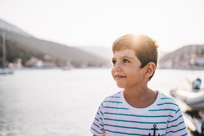 Cute kid smiling at sunset with the sea in the background