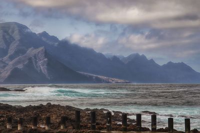 Scenic view of sea and mountains against sky