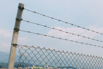 Low angle view of chainlink fence against sky