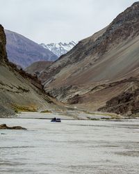 Scenic view of river and mountains against sky