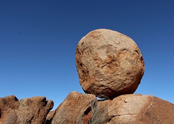 Low angle view of rock formation against clear blue sky