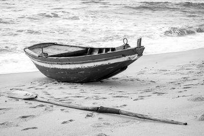 Abandoned boat moored on shore