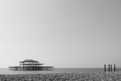 Silhouette brighton pier in sea against sky