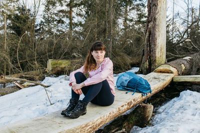 Portrait of  girl who sits on  bench and rests while walking in the forest. hiking. active lifestyle