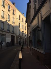 Empty road amidst buildings in city