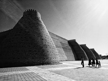 People at historical building against clear sky