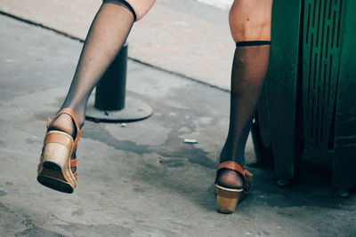 Low section of woman standing on footpath