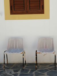 Empty chairs and tables against wall at home