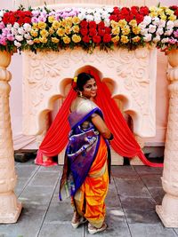 Portrait of woman wearing sari while standing at decorated entrance