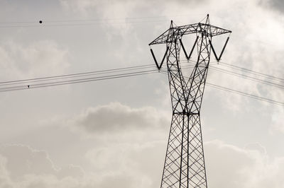 Low angle view of electricity pylon against sky