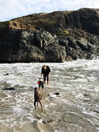 Woman standing with dogs at beach