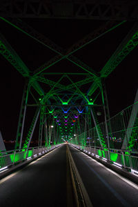 Illuminated bridge against clear sky at night