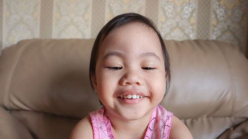 Portrait of smiling girl on sofa at home