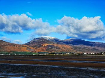 Scenic view of lake and mountains against blue sky