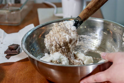 Close-up of hand holding ice cream in bowl