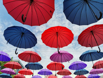 Low angle view of umbrellas hanging against sky
