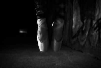 Low section of ballet dancer in darkroom
