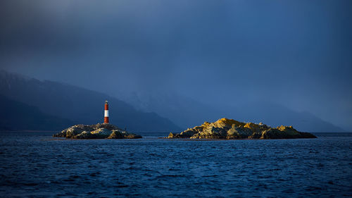 Lighthouse by sea against sky