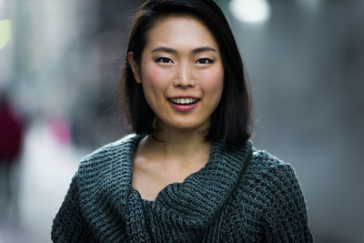 Close-up portrait of smiling young woman outdoors