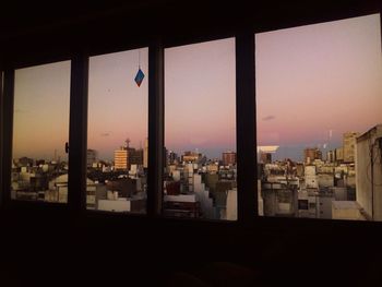 Buildings in city against clear sky during sunset