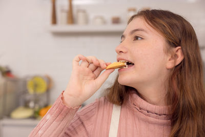 Portrait of woman eating food at home