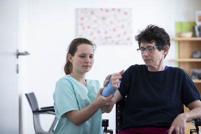 Nurse tigthing a armbracer to a patient female