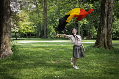 Portrait of a girl with a belgian flag in the park.